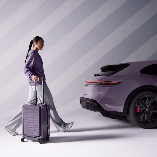Vrouw met Porsche trolley voor een Porsche Taycan.