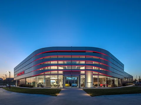 A picture of a Porsche Center at dusk