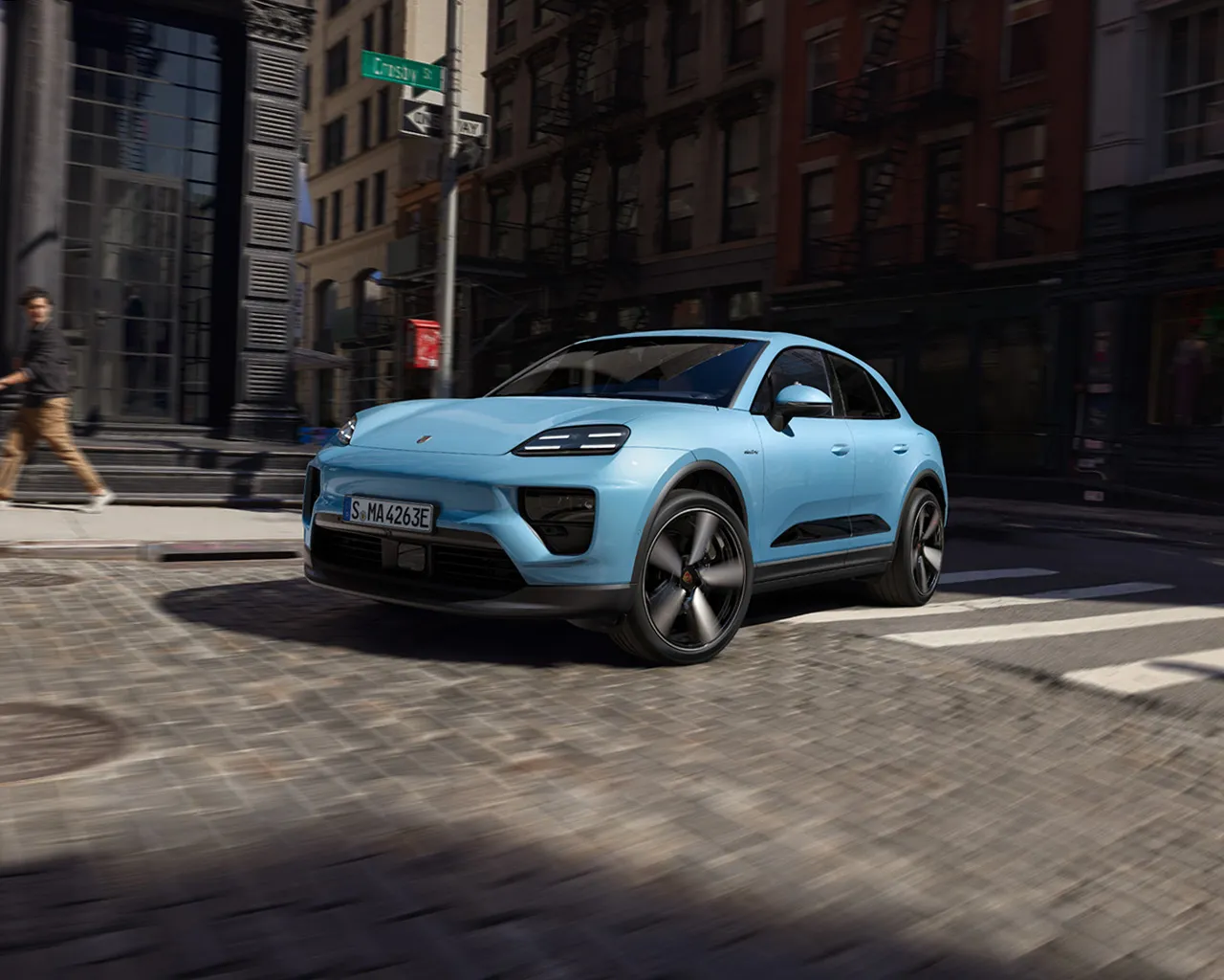 Porsche Macan Electric jedzie drogą, a kamera pokazuje ujęcia z różnych kątów