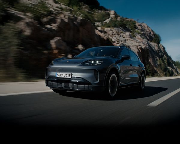 A Porsche Cayenne driving on an open road.