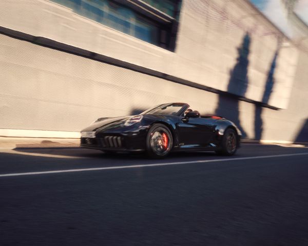 A Porsche 911 driving down a road.