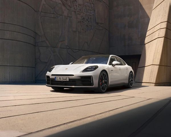 A Porsche Panamera parked in front of a modern building.