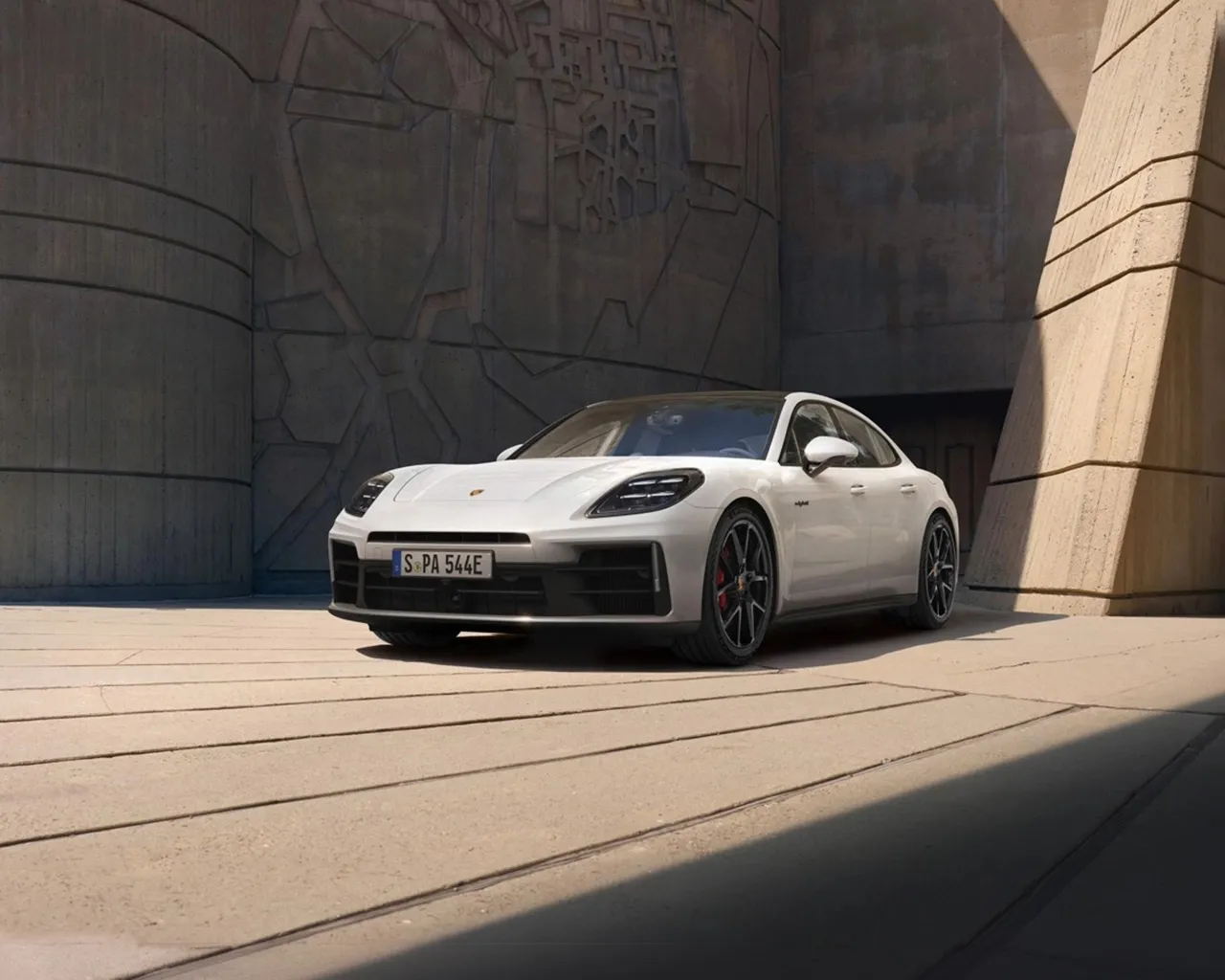 A Porsche Panamera parked in front of a modern building.