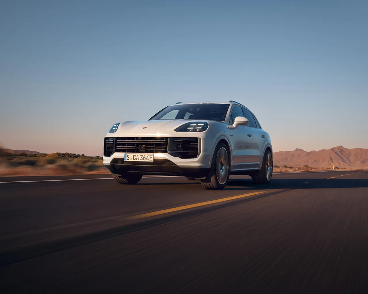 A Porsche Cayenne driving on an open road.