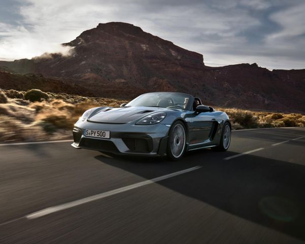 Porsche 718 Spyder RS driving on the road between rock formations.