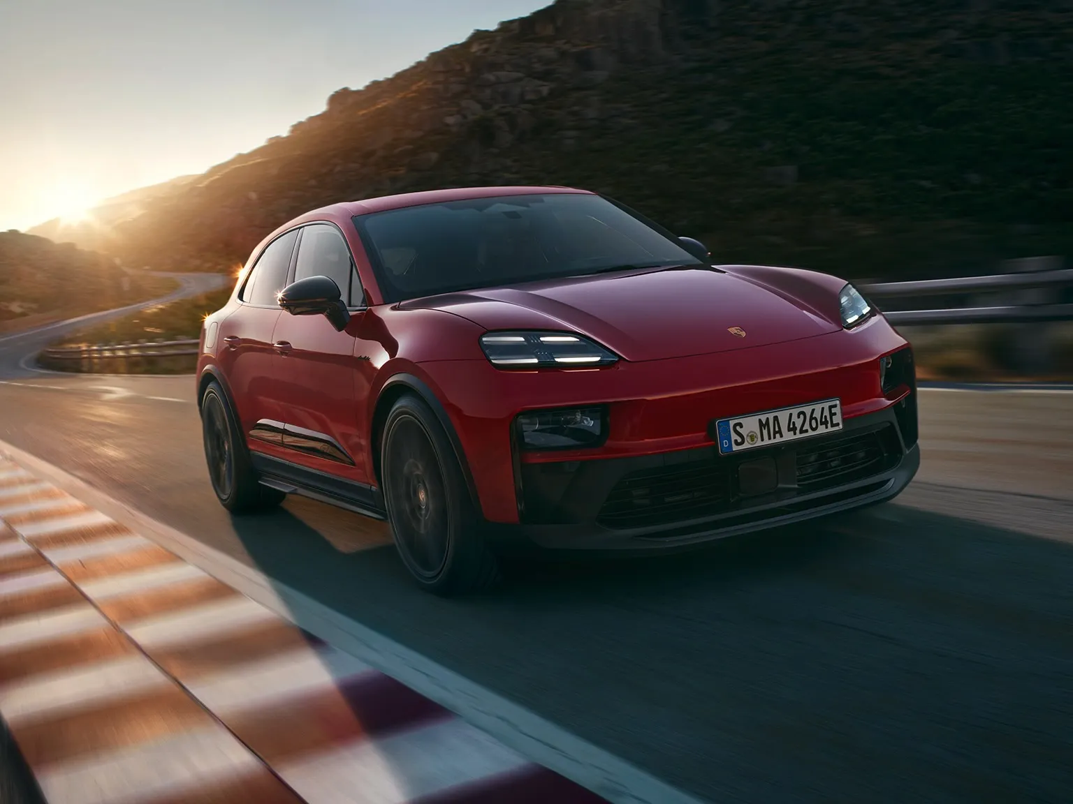 Front shot of a Macan GTS driving on a road in the countryside.