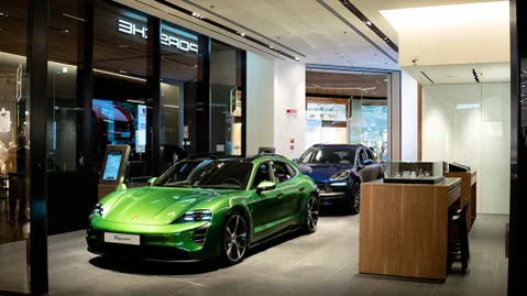 Un negozio Porsche con due veicoli all'interno in esposizione.