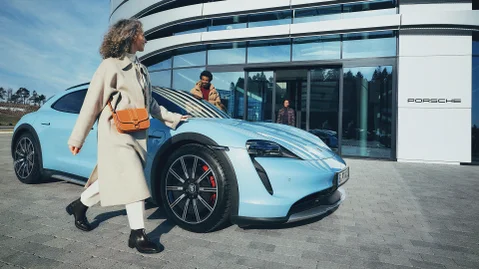 Koppel staat voor een Porsche Centrum met daartussen een Porsche Macan.