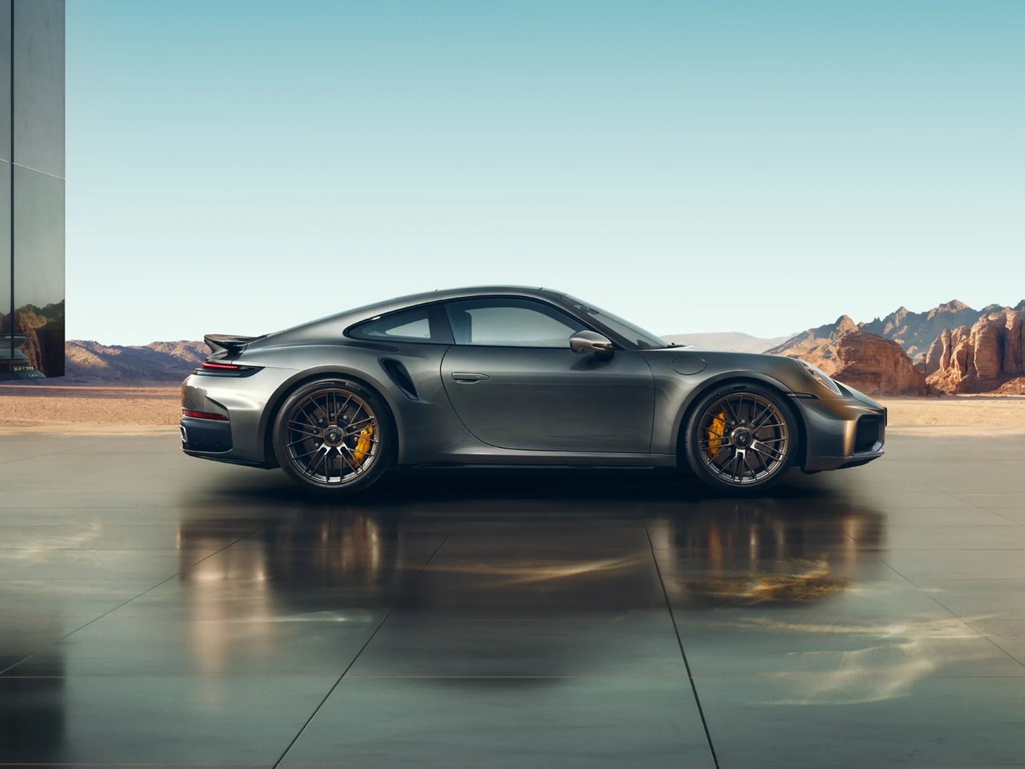 Side shot of a 911 Turbo S with mountains in the background. 