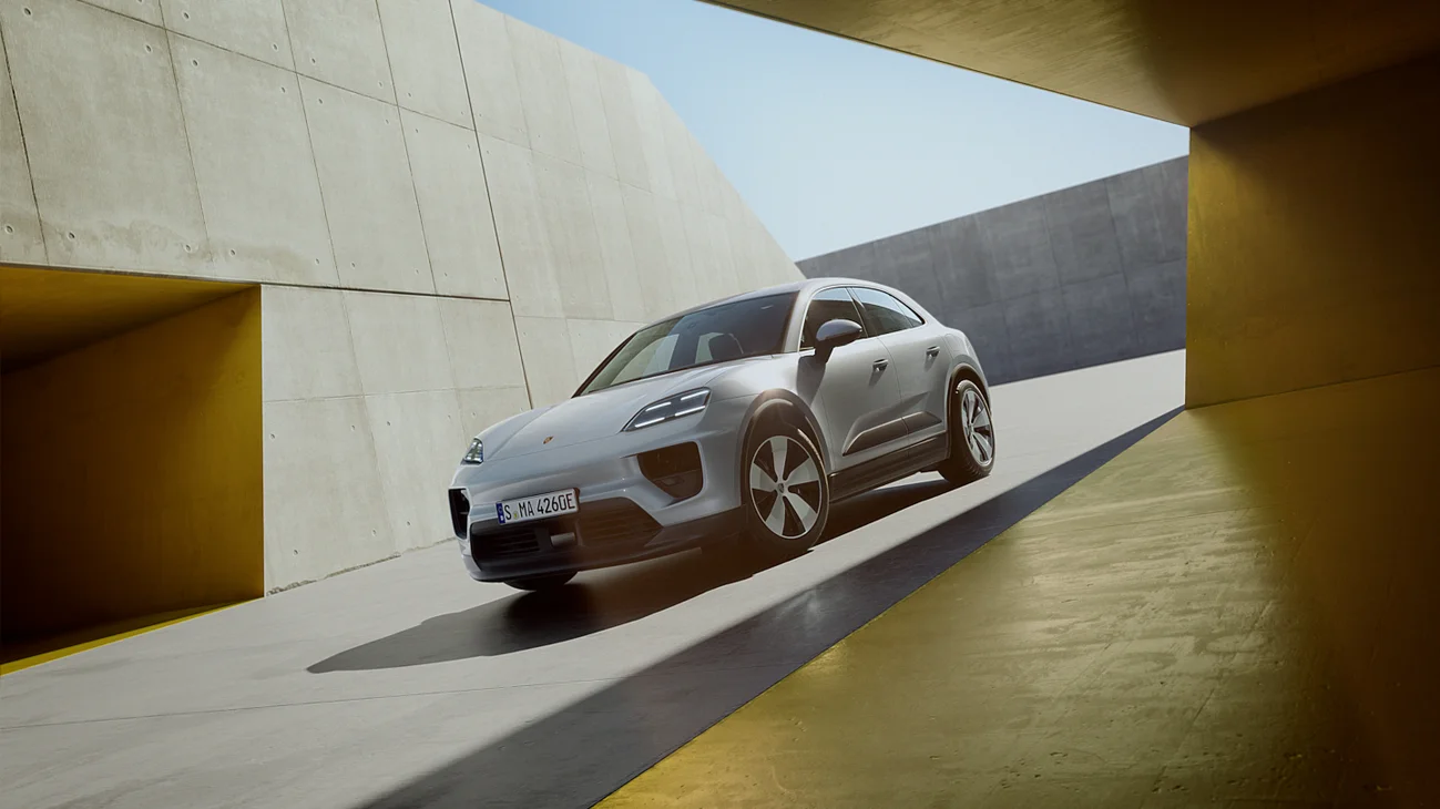 Front view of a Porsche Macan standing in front of modern architecture.