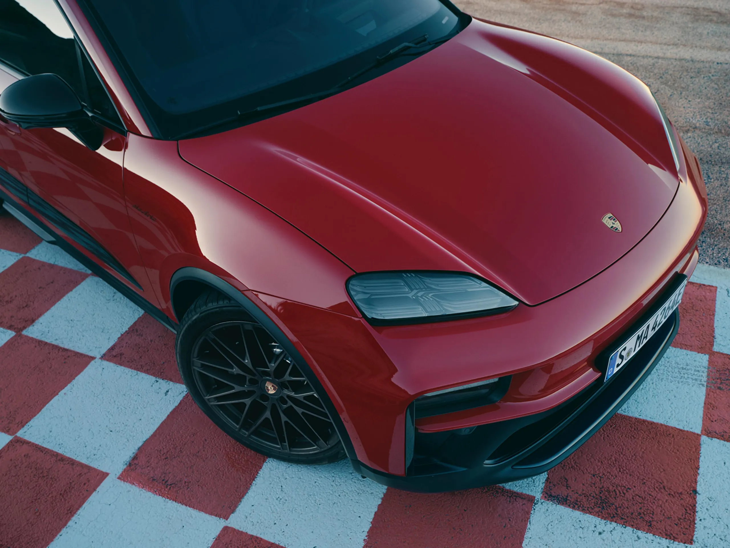 Front shot of a Macan GTS driving on a road in the countryside.