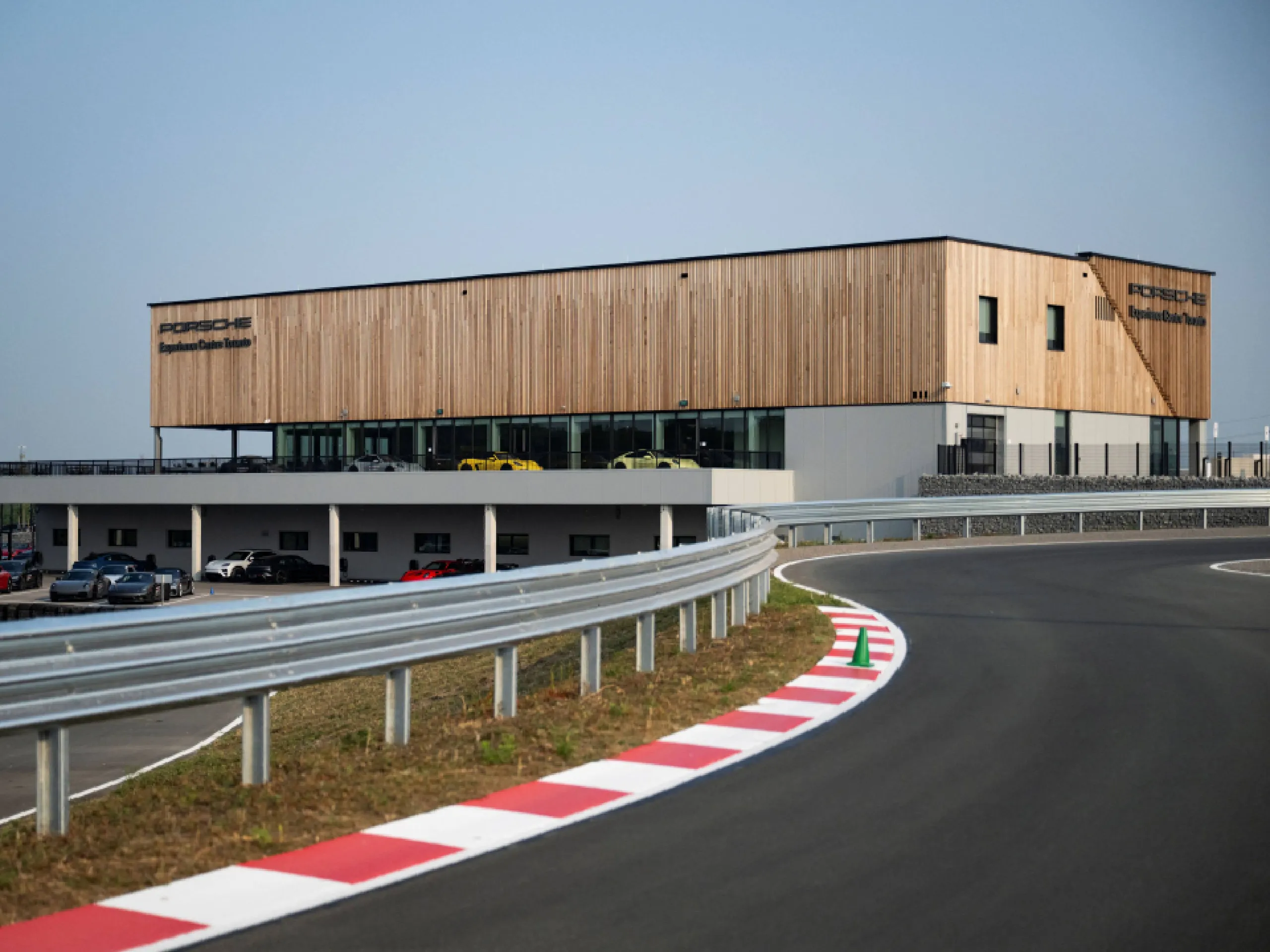 A low angle shot from a driving circuit with a building with modern Porsche building in the background.