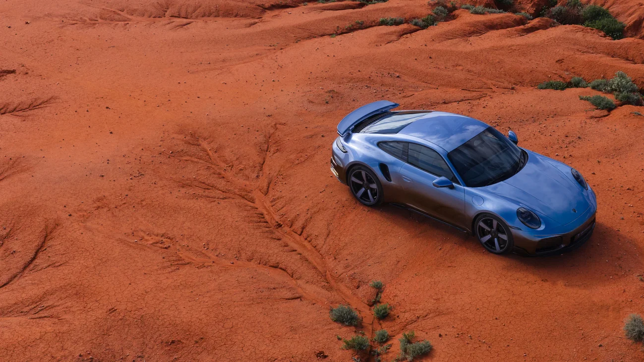 Top view of the 911 Turbo S Land Down Under on orange desert ground.